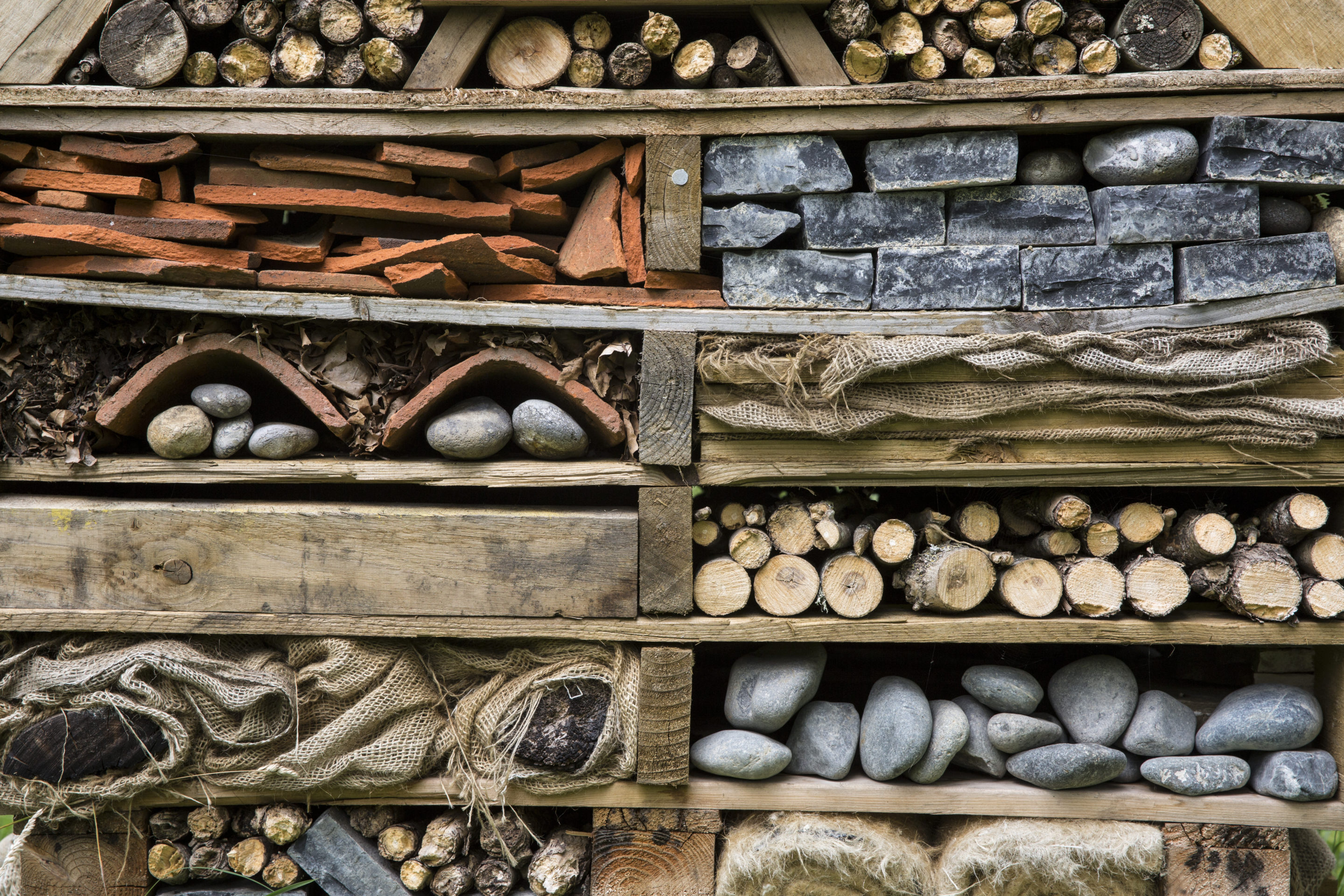 Close up of large bug house with several layers of different materials.